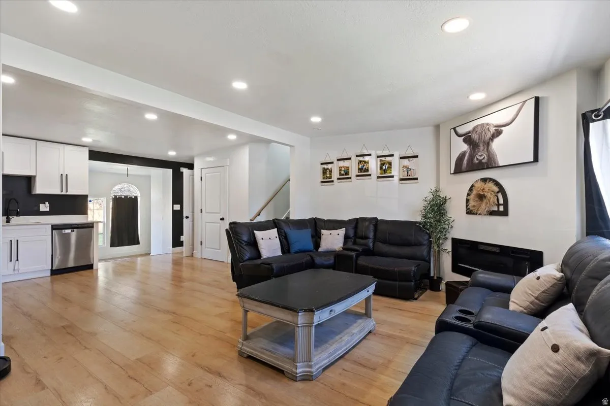 Living area with light wood-style flooring and recessed lighting