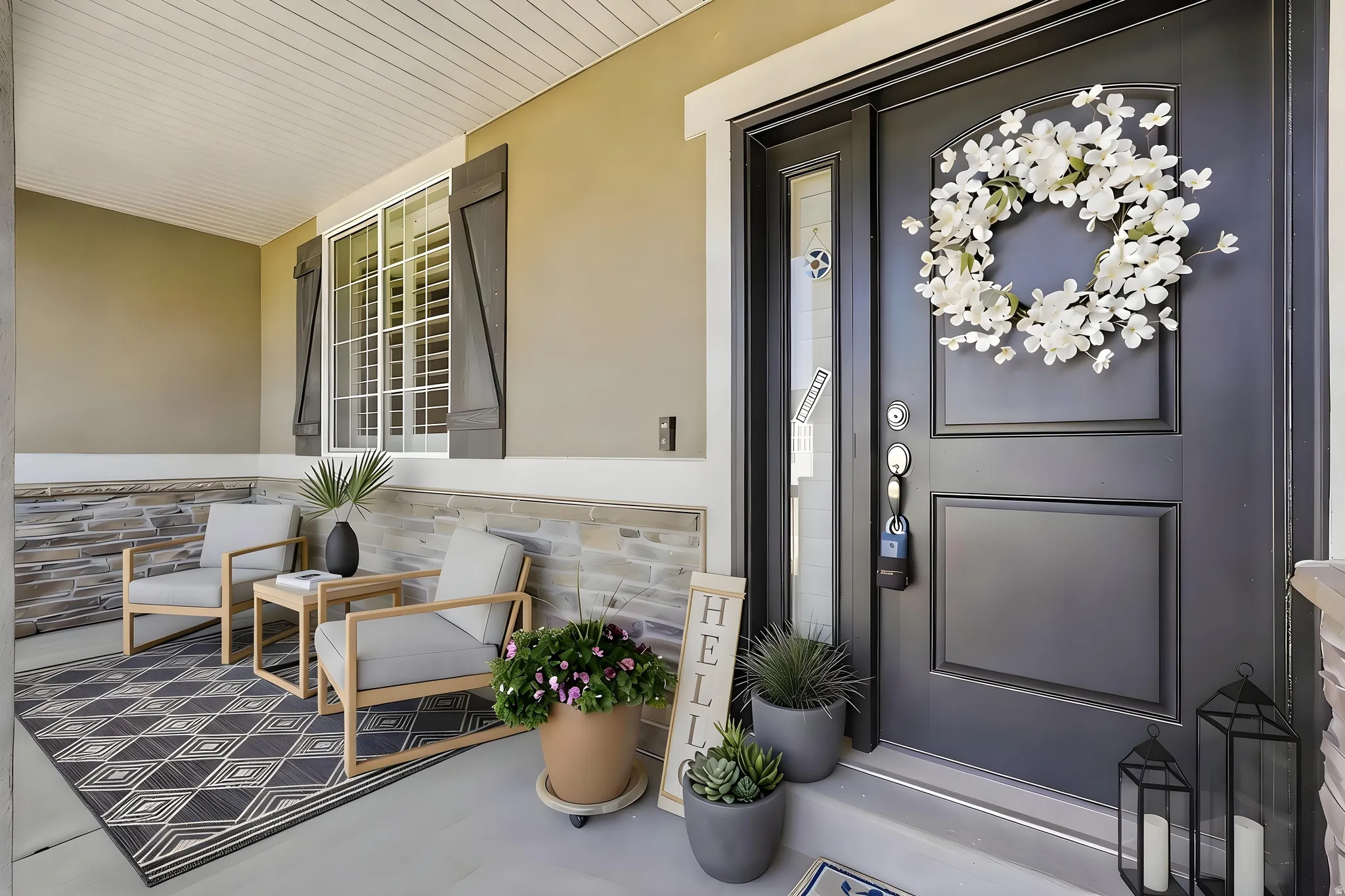 Covered front porch featuring a dark paneled entry door with sidelight, stone veneer detailing, and a window with functional shutters