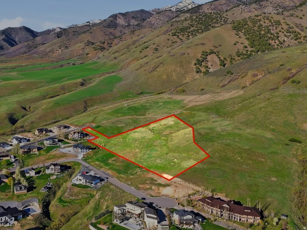 Aerial overview of property's location featuring property boundaries highlighted and a mountain backdrop