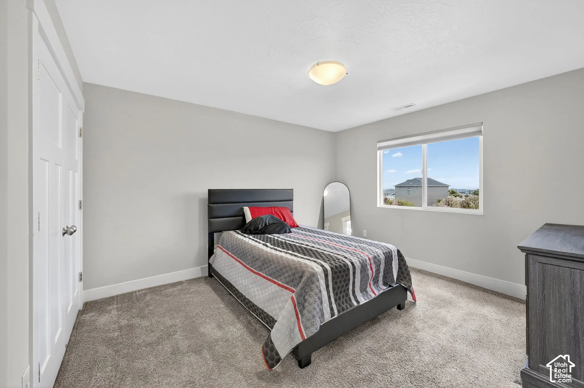 Bedroom with light carpet and baseboards