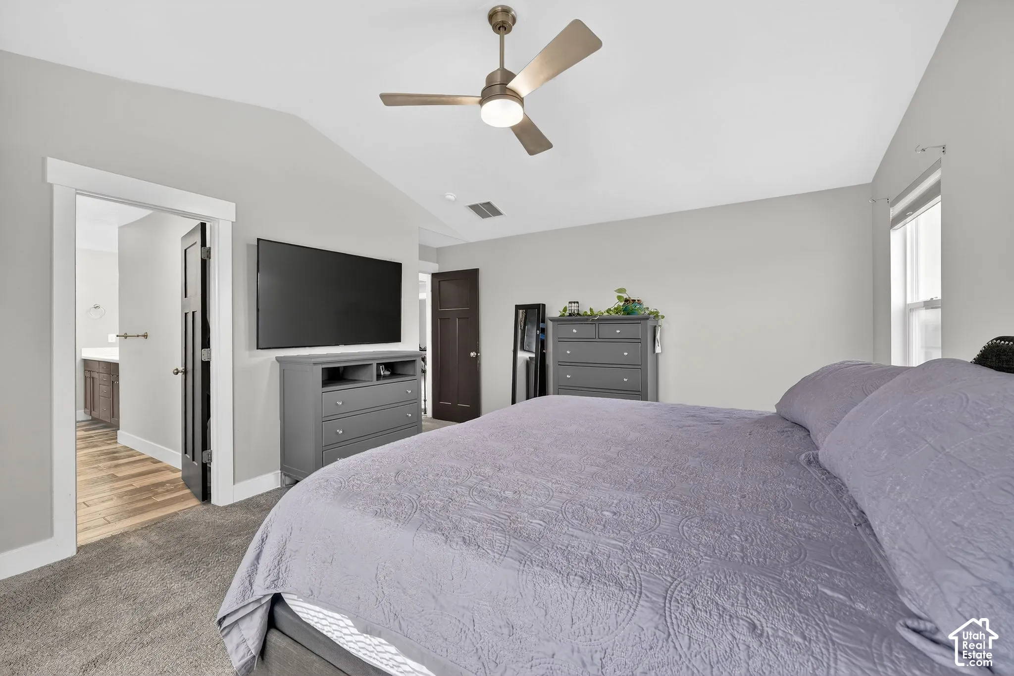 Bedroom with carpet flooring, a ceiling fan, and ensuite bathroom