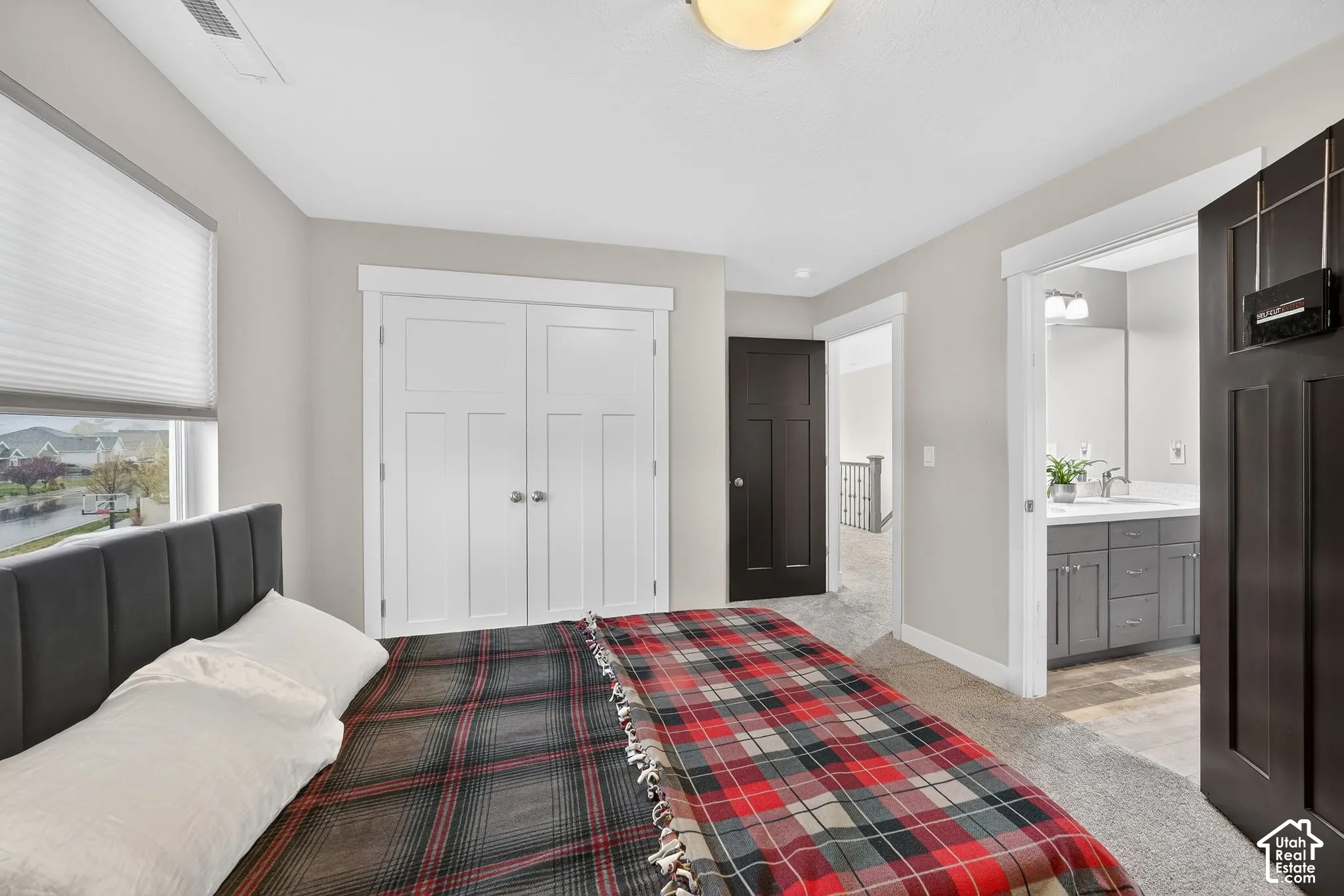 Bedroom with light carpet, a closet, and ensuite bath