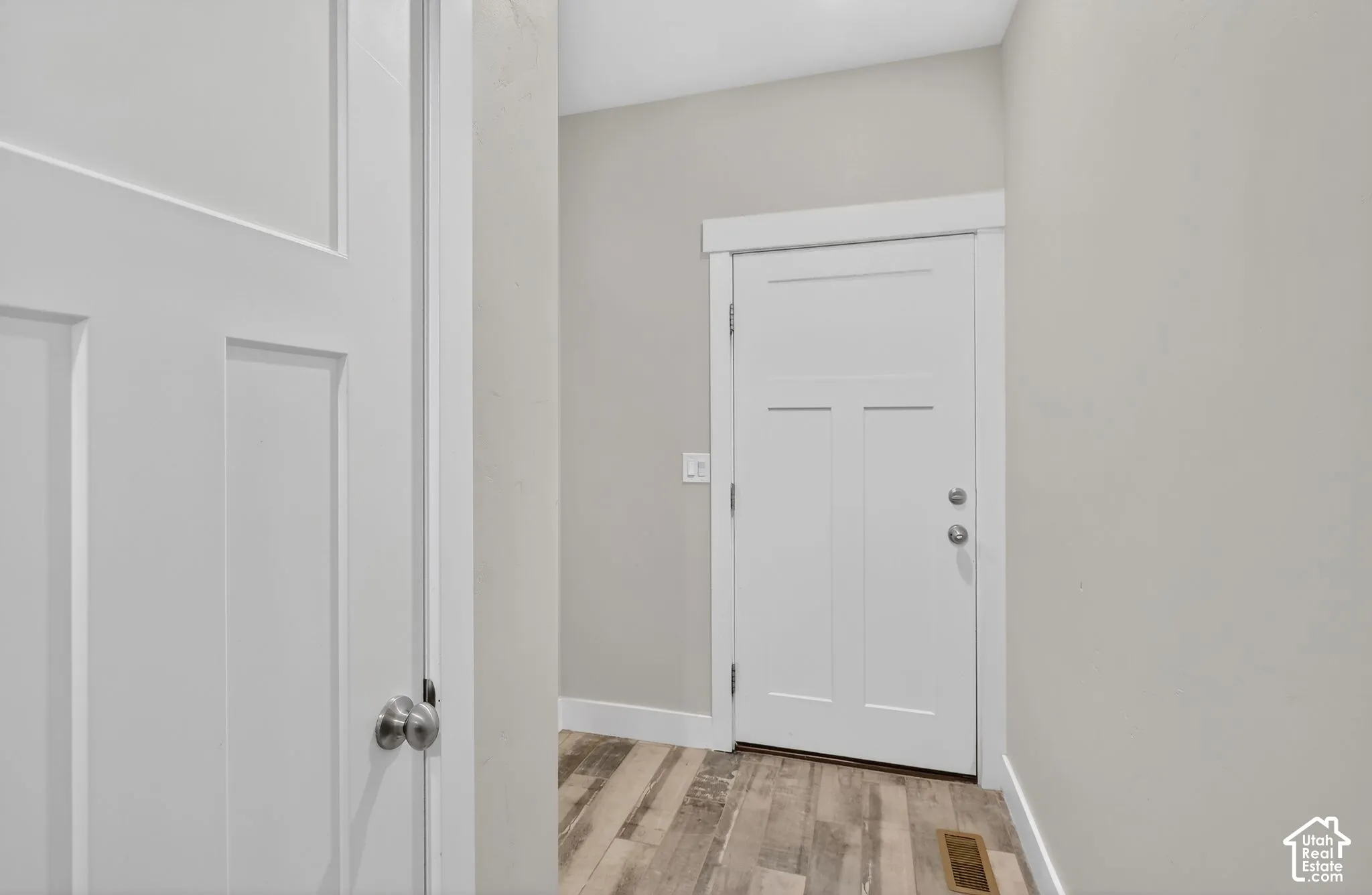 Foyer entrance featuring light wood-style floors and baseboards