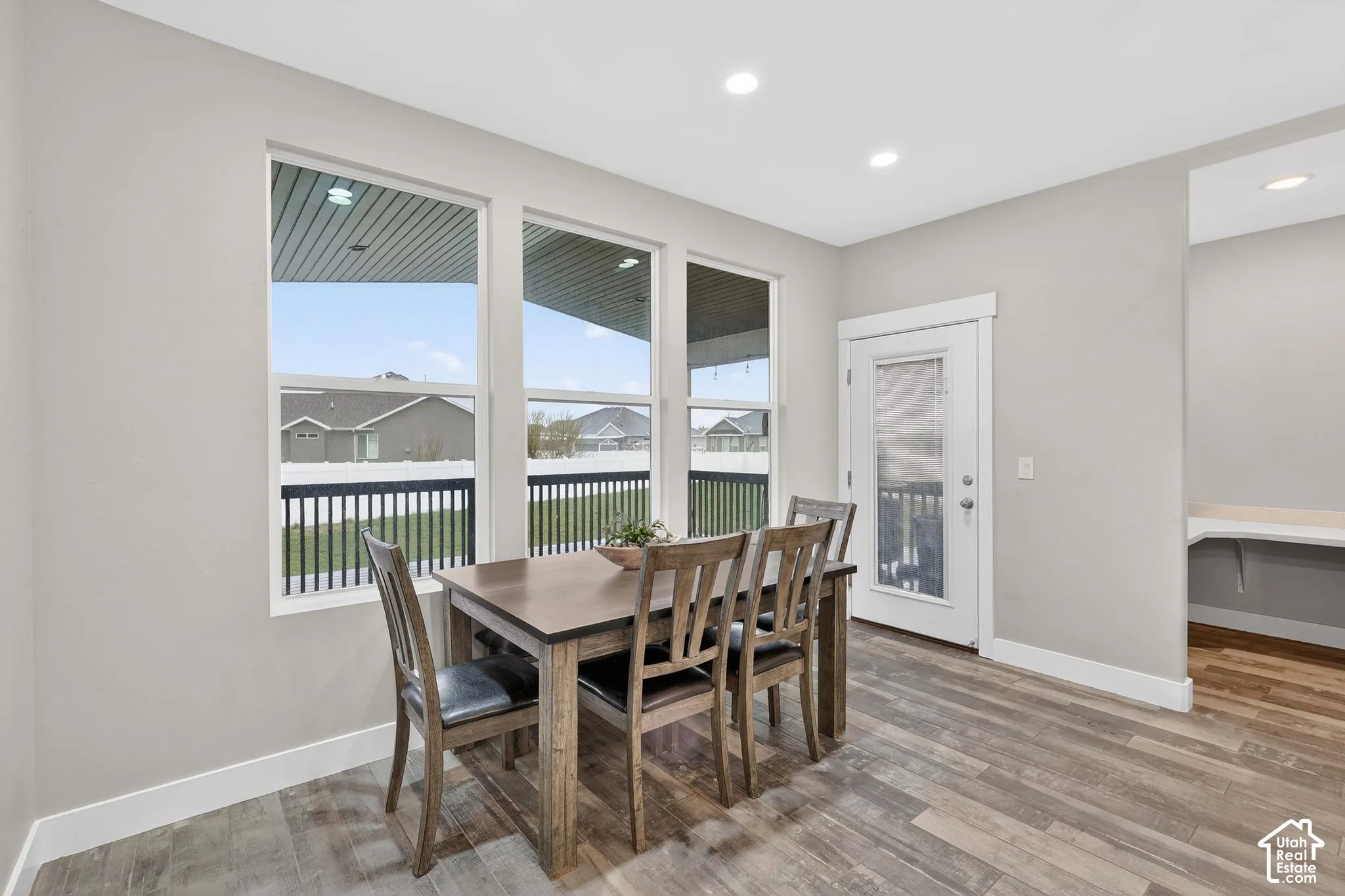 Dining area with light wood finished floors and recessed lighting