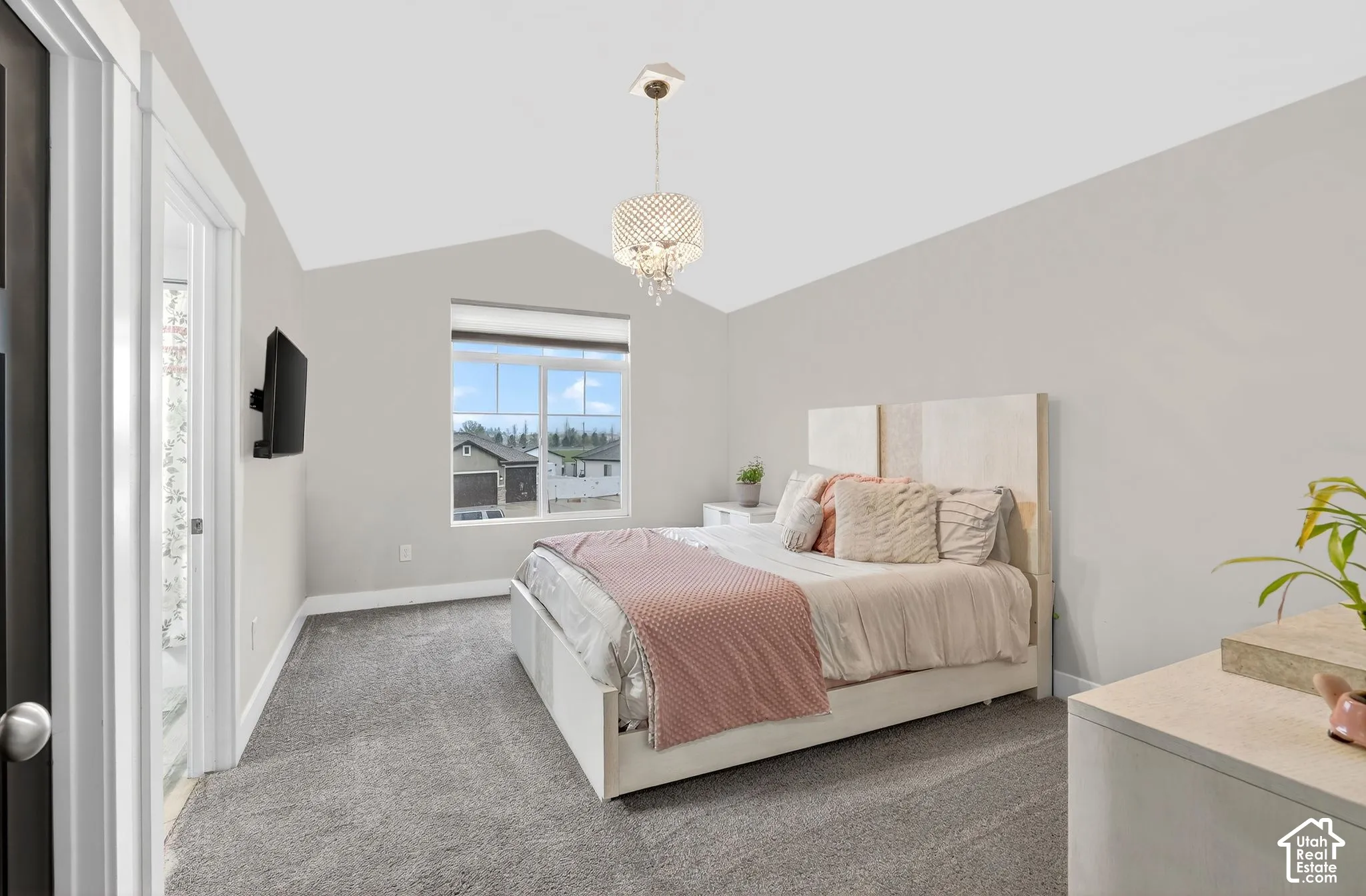 Carpeted bedroom with baseboards and a chandelier