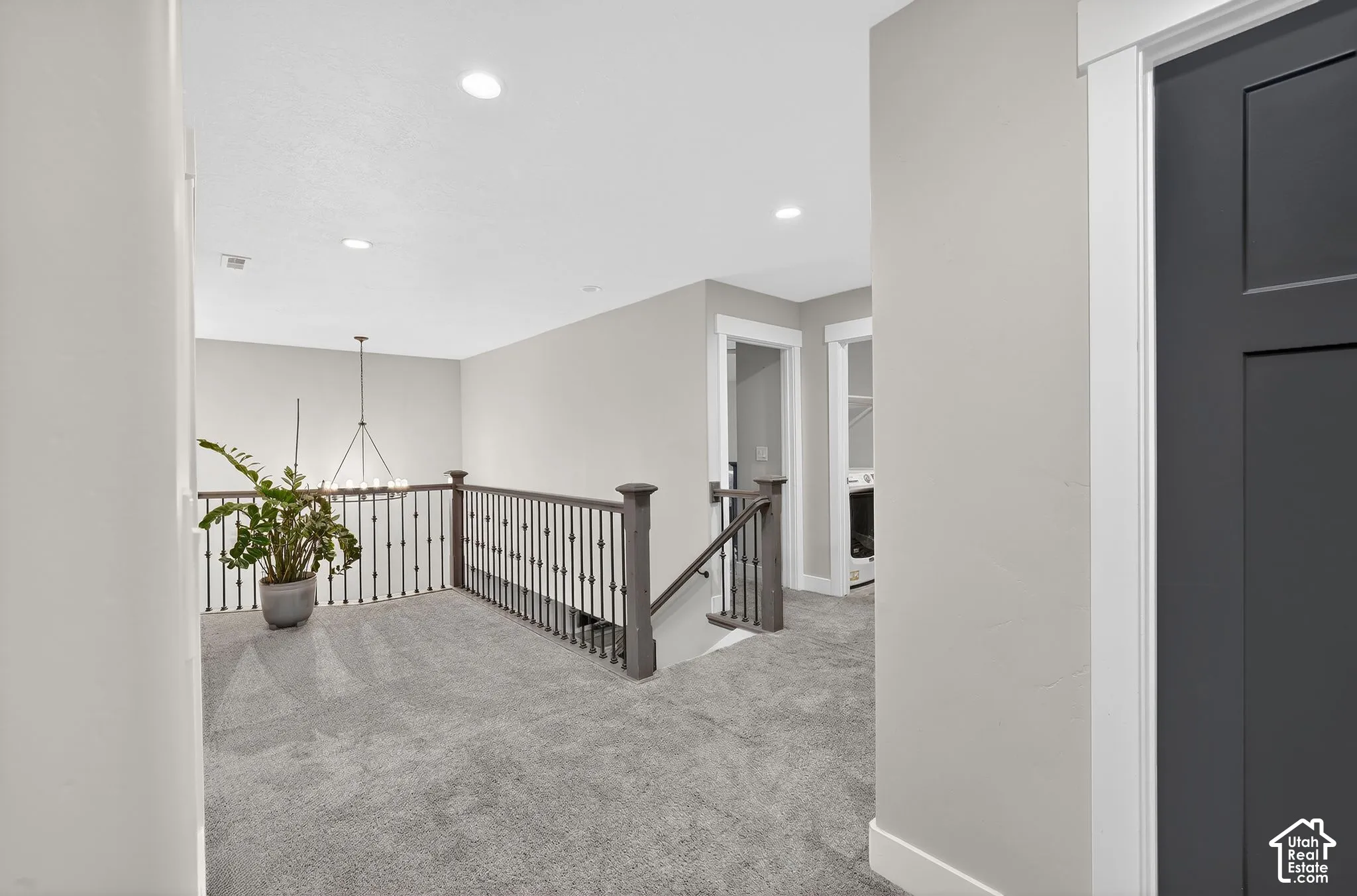 Corridor featuring an upstairs landing, carpet floors, and a chandelier