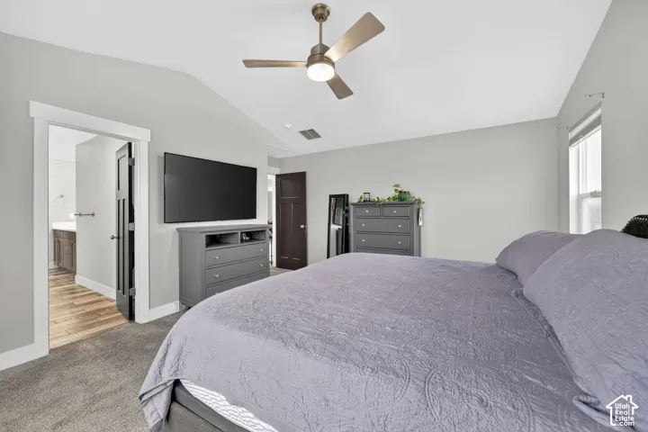 Bedroom with carpet flooring, a ceiling fan, and ensuite bathroom