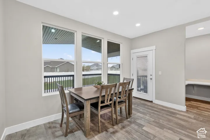 Dining area with light wood finished floors and recessed lighting