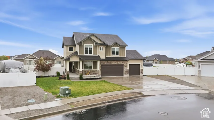 Craftsman-style home with a residential view, driveway, stone siding, roof with shingles, and a porch