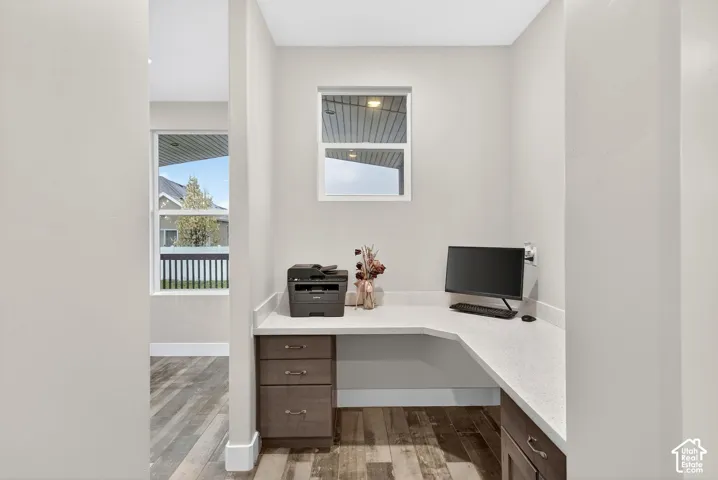Home office featuring built in study area and light wood-type flooring