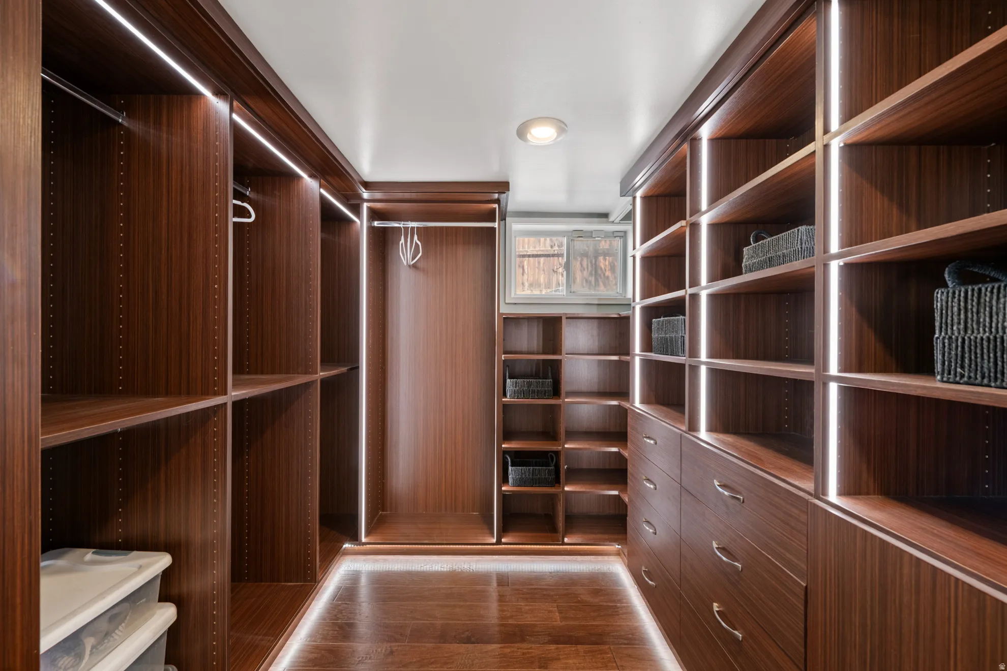 Walk in closet with dark wood finished floors