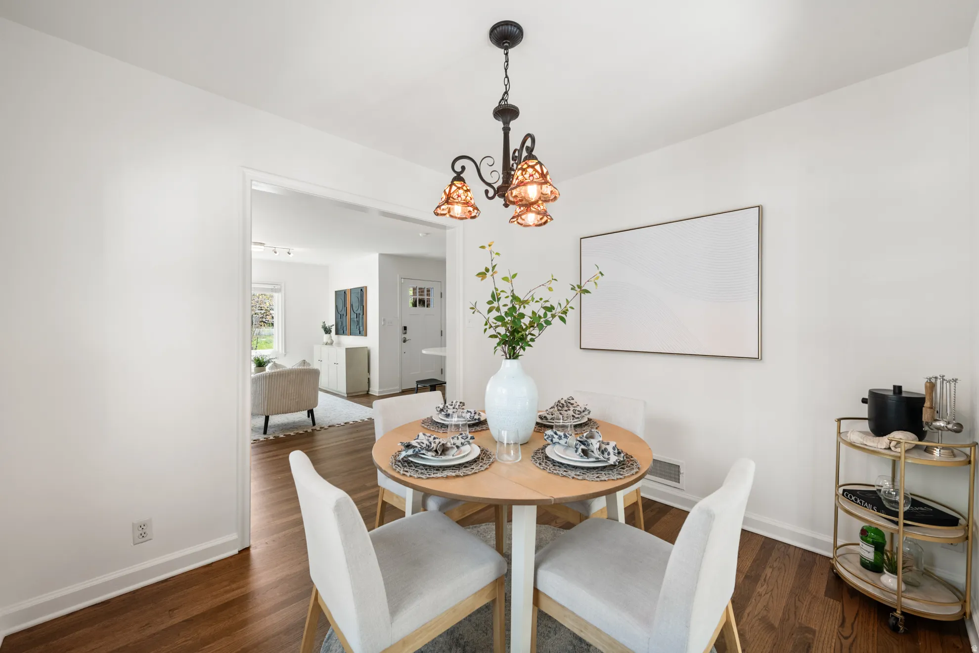 Dining space featuring suspended lighting and dark wood-style flooring