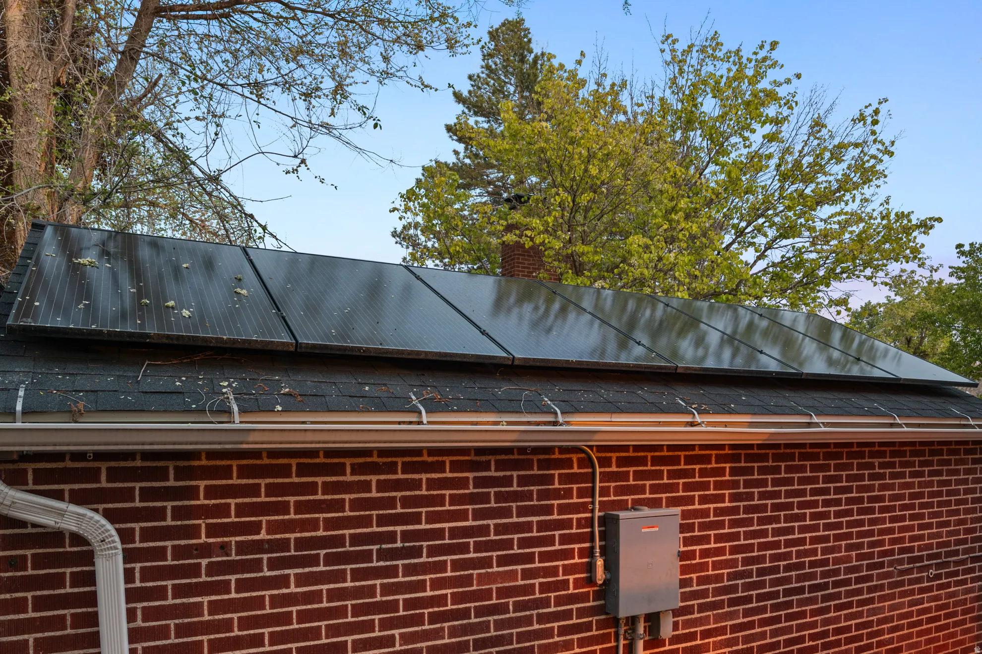 Exterior view of brick siding, a chimney, and a metal roof