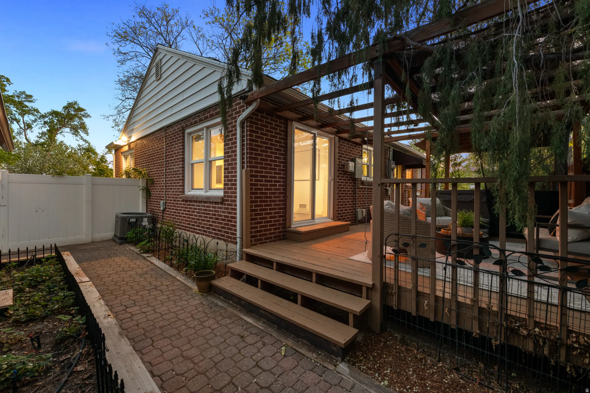 Rear view of house featuring brick siding and a wooden deck