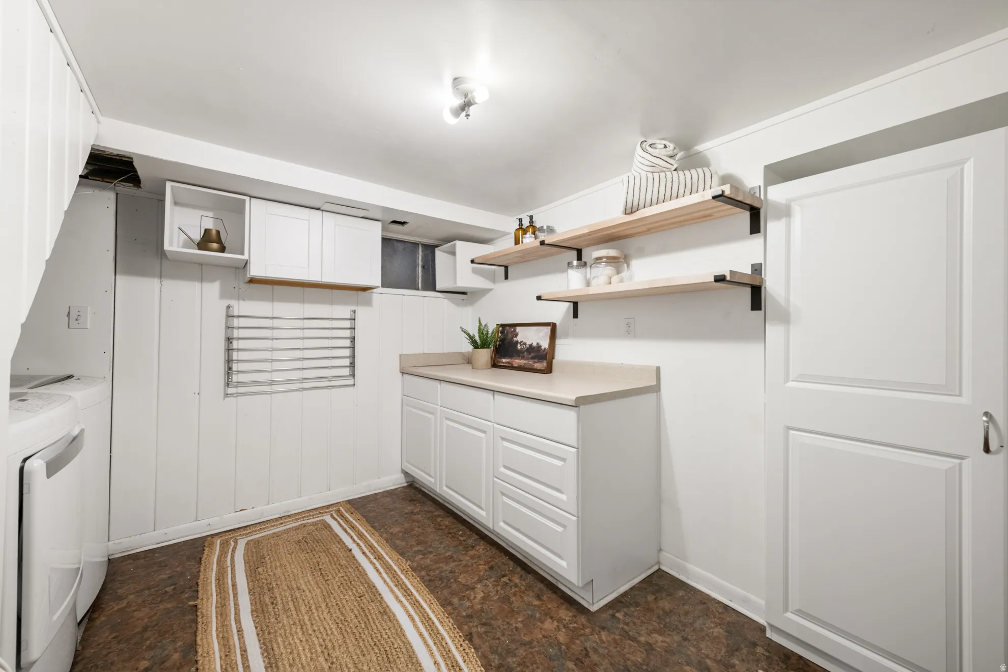 Kitchen featuring open shelves, white cabinetry, light countertops, and separate washer and dryer