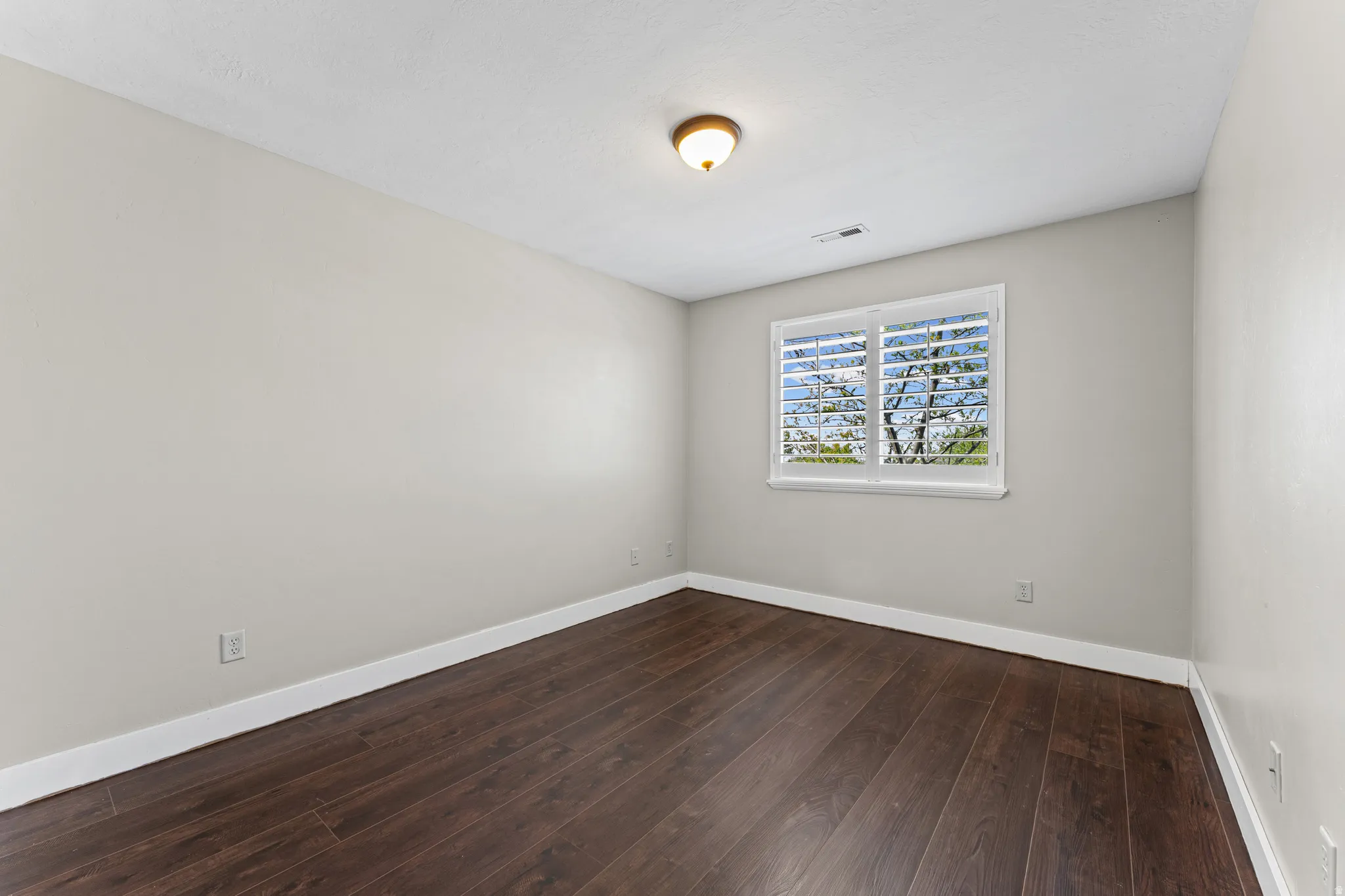 Spare room featuring dark wood finished floors