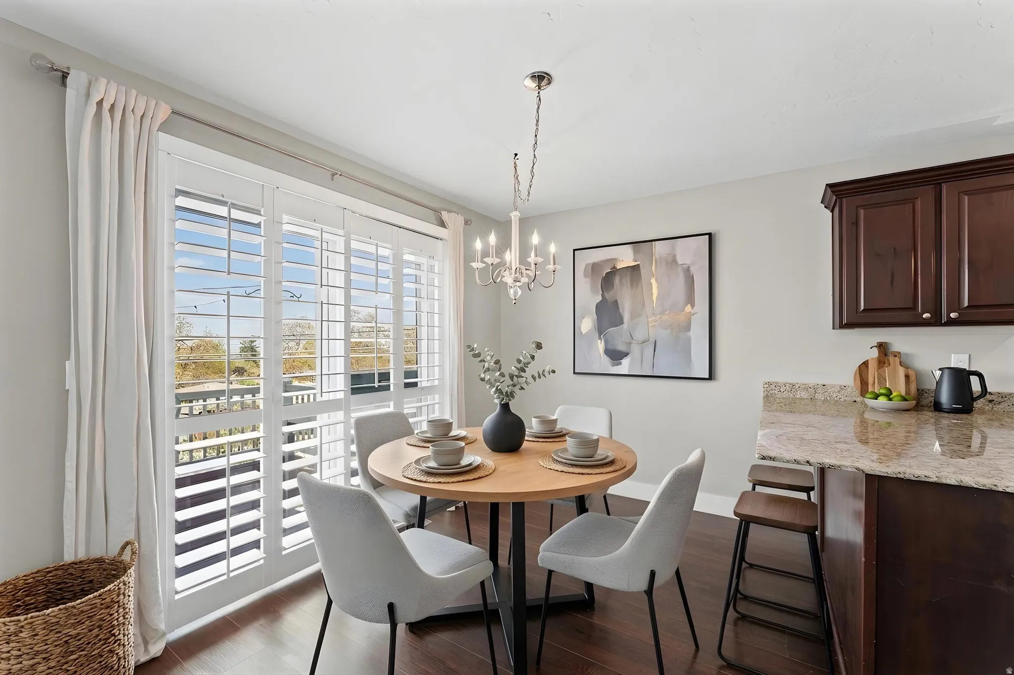 Dining room with hanging lights and dark wood-style floors