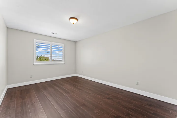 Unfurnished room featuring dark wood-style flooring