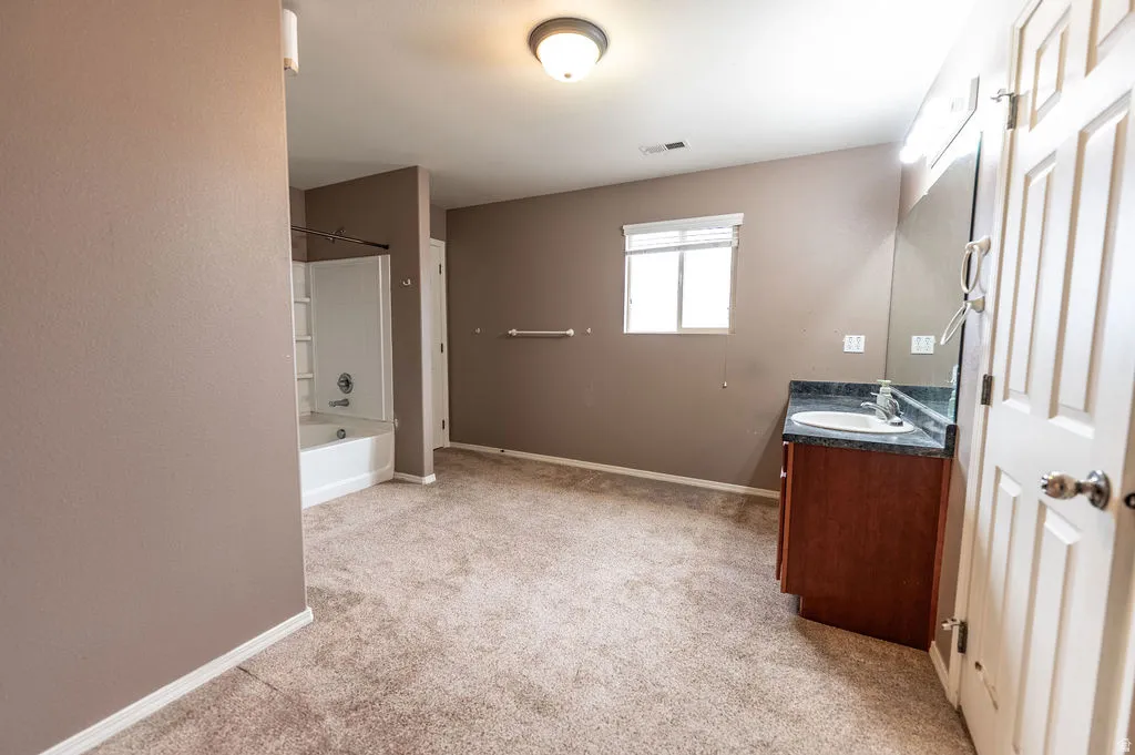 Full bath featuring vanity, light colored carpet, and bathtub / shower combination