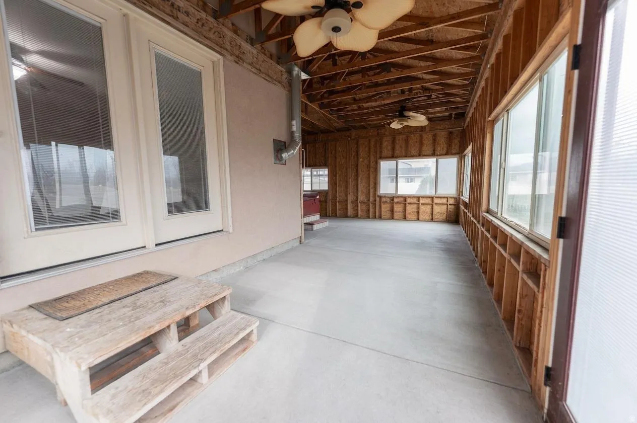 Unfurnished sunroom featuring ceiling fan
