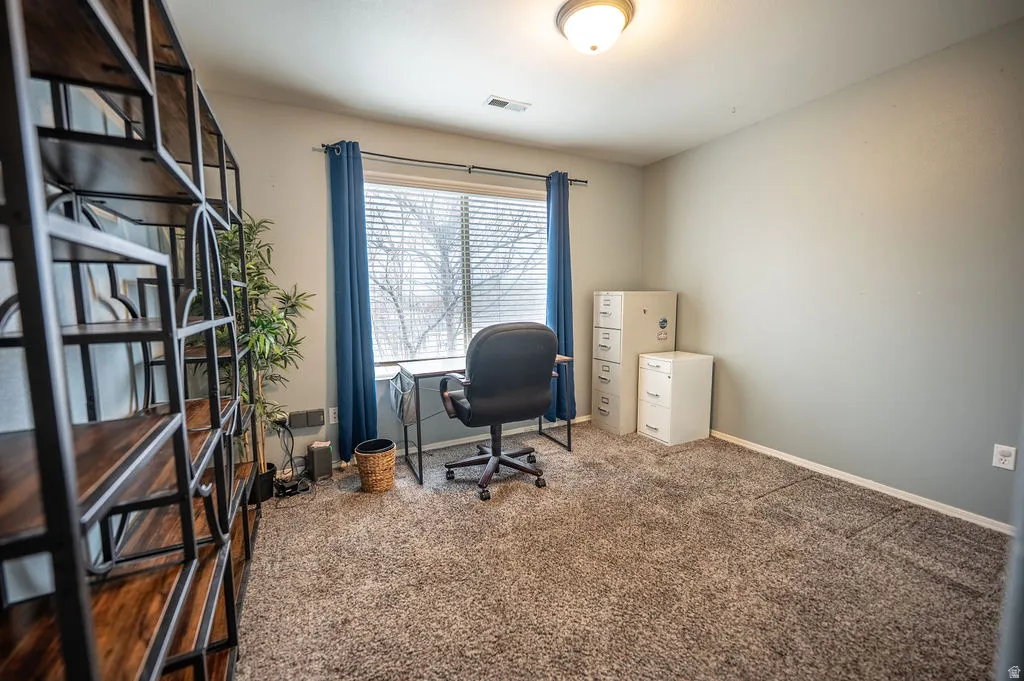 Home office featuring carpet floors and baseboards