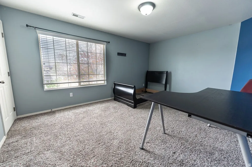 Office area featuring baseboards and light colored carpet