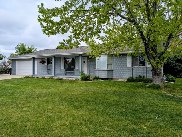 Ranch-style house featuring brick siding, a front lawn, an attached garage, and concrete driveway.