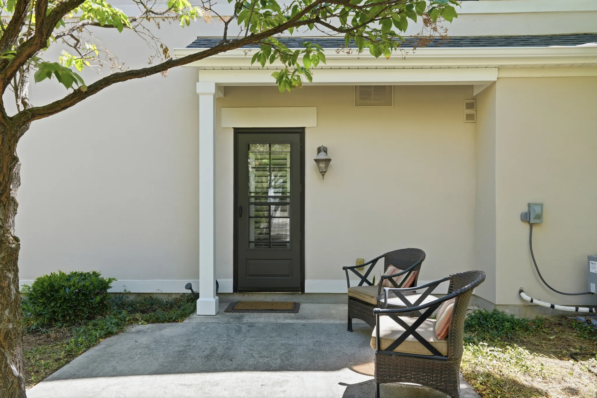 Covered entry with a dark-paneled door featuring a full-light window