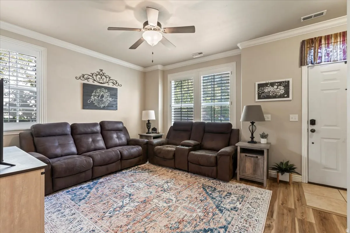 Living area featuring ornamental molding, a ceiling fan, and light wood finished floors