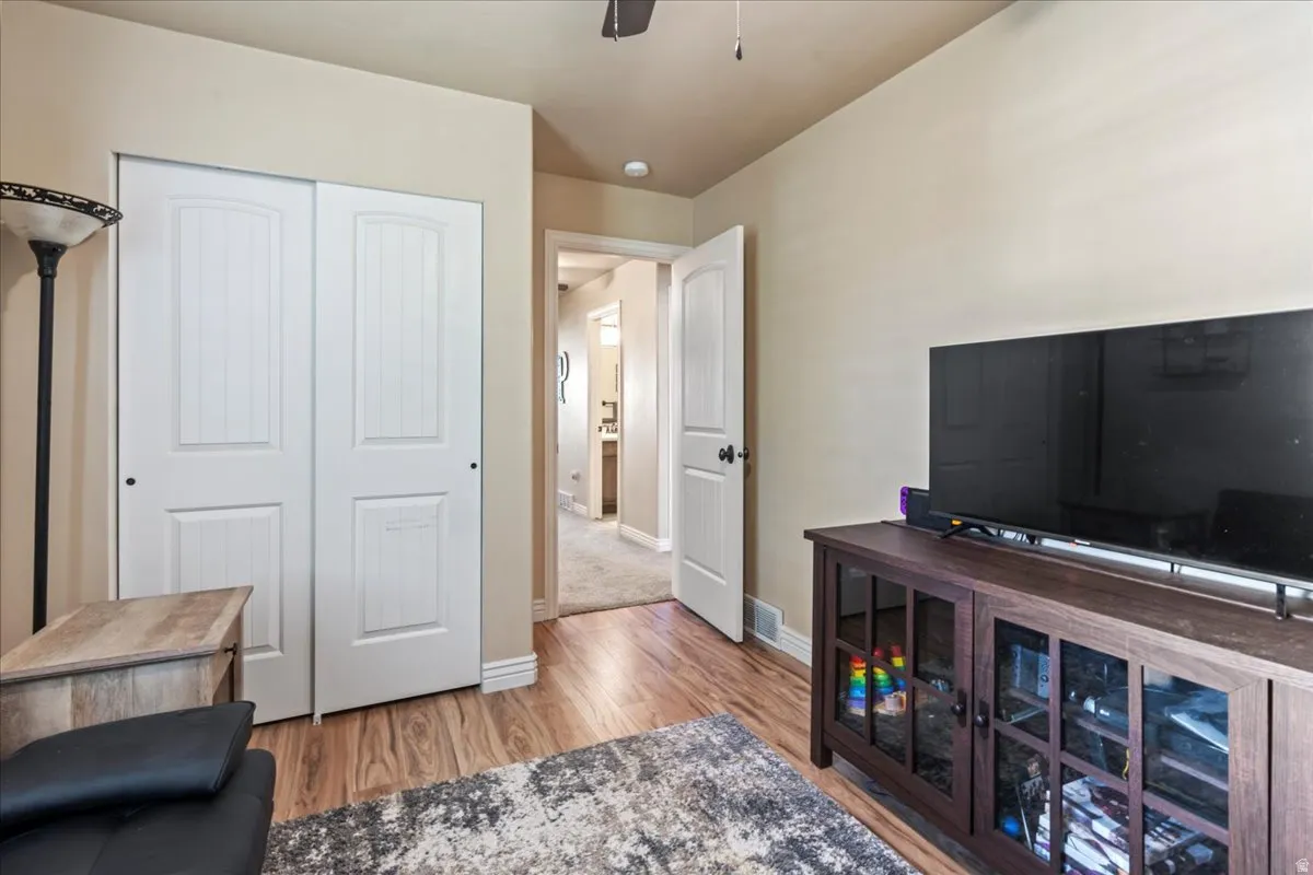 Sitting room with light wood-style flooring and ceiling fan