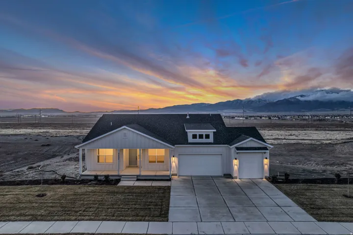 A beautiful modern farmhouse with a large covered porch, board and batten siding, a generous three car garage, with an incredible mountain view.