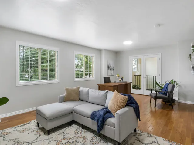 Spacious room featuring wood-finish flooring, light gray walls, and white trim