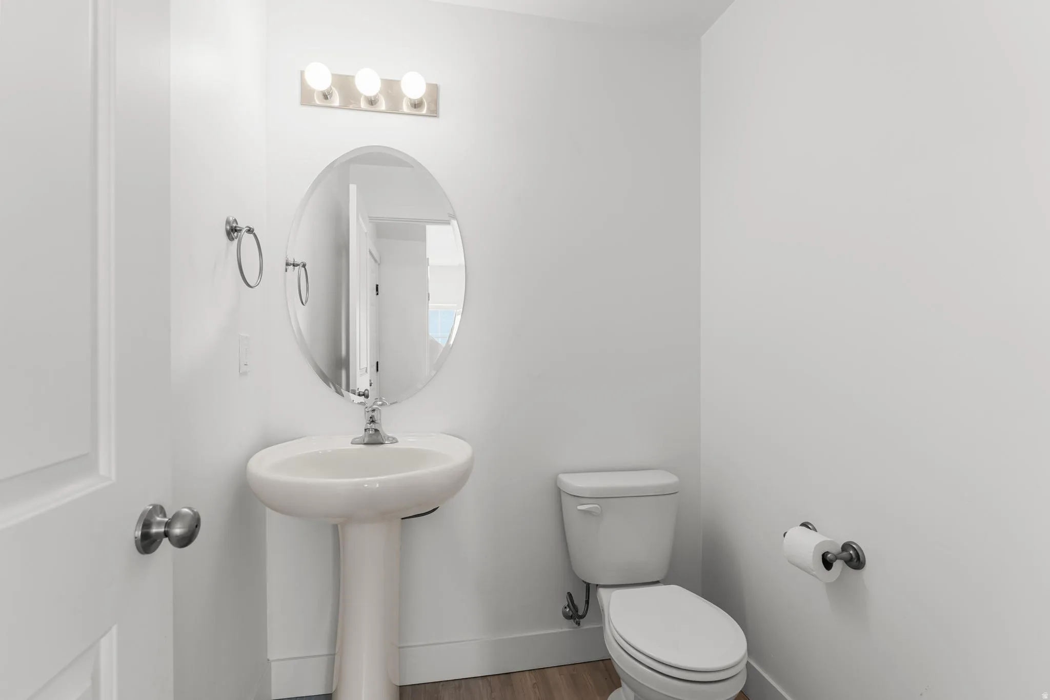 Bathroom with toilet and wood finished floors