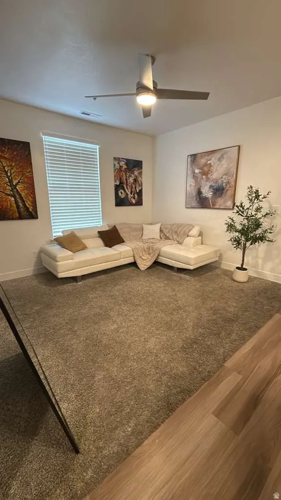 Living area featuring a ceiling fan and carpet floors