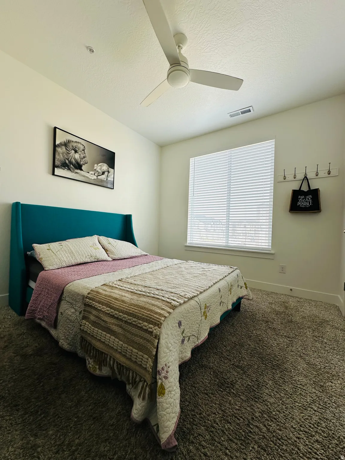 Bedroom featuring carpet floors, ceiling fan, and a textured ceiling