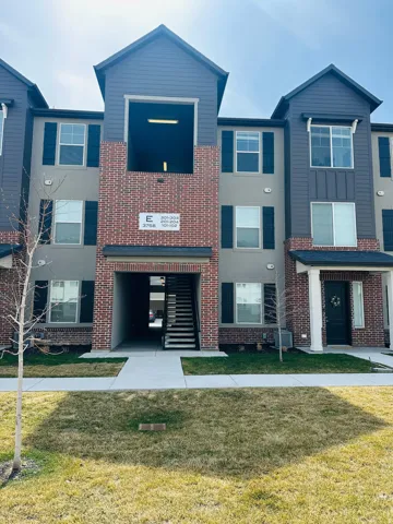 View of front facade with brick siding and a front lawn