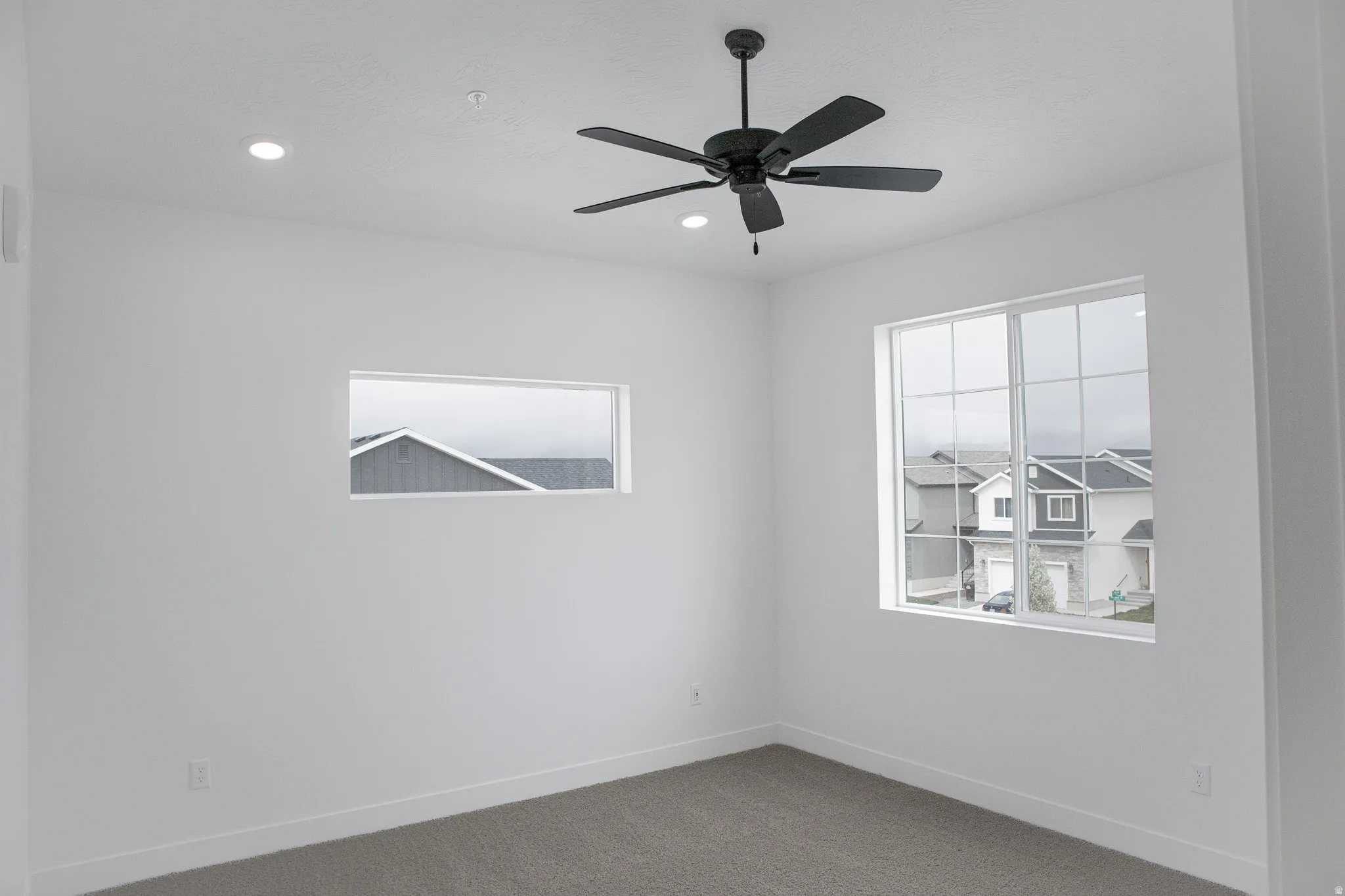 Primary bedroom with vaulted ceiling and ceiling fan.