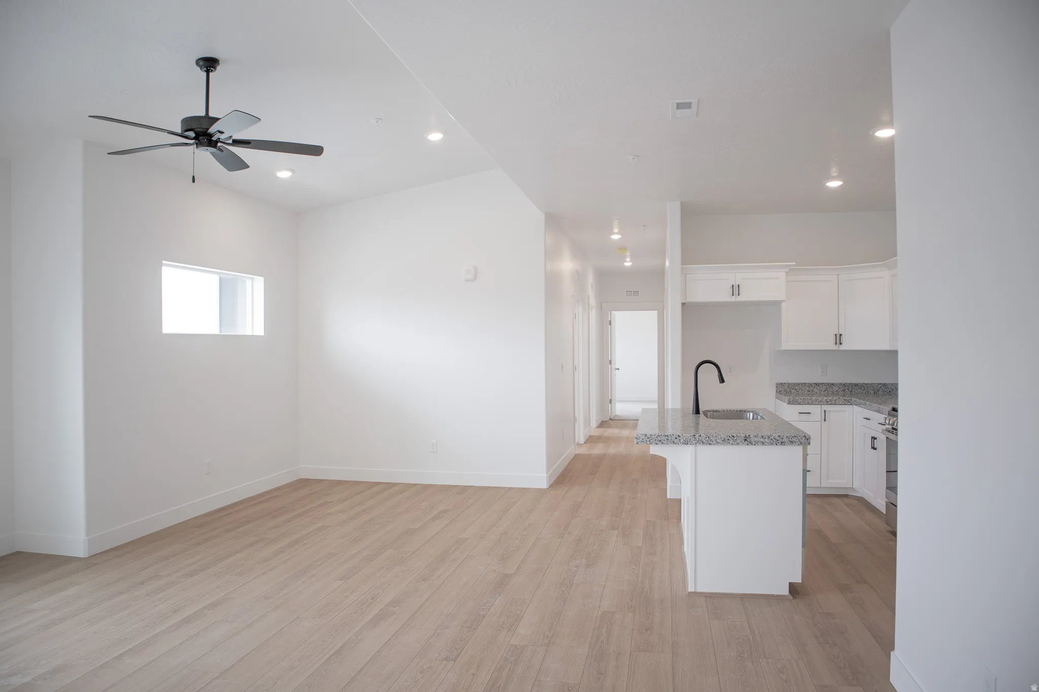 Family room/dining area with vaulted ceiling and ceiling fan.