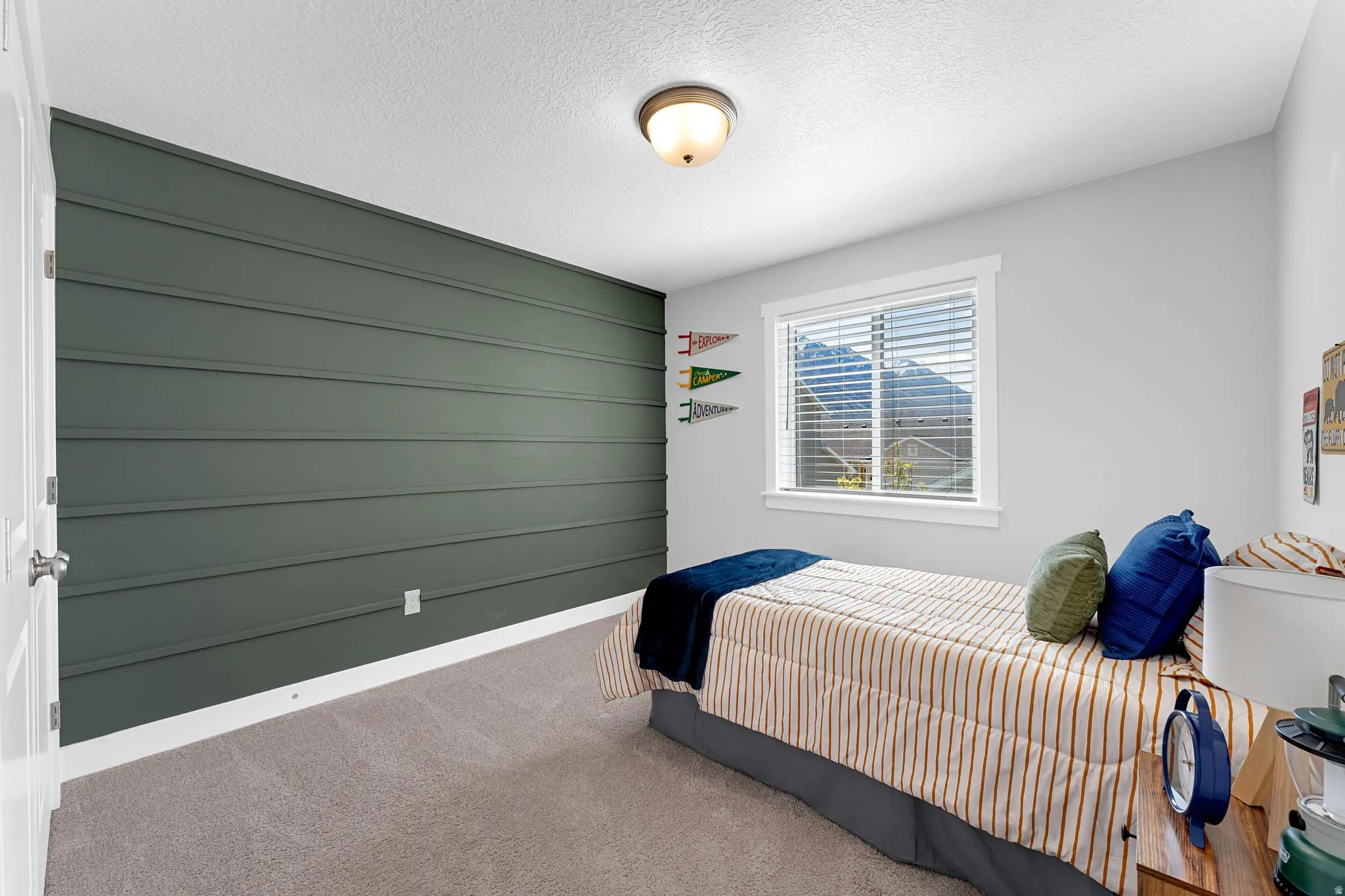 Bedroom with an accent wall, carpet, and a textured ceiling