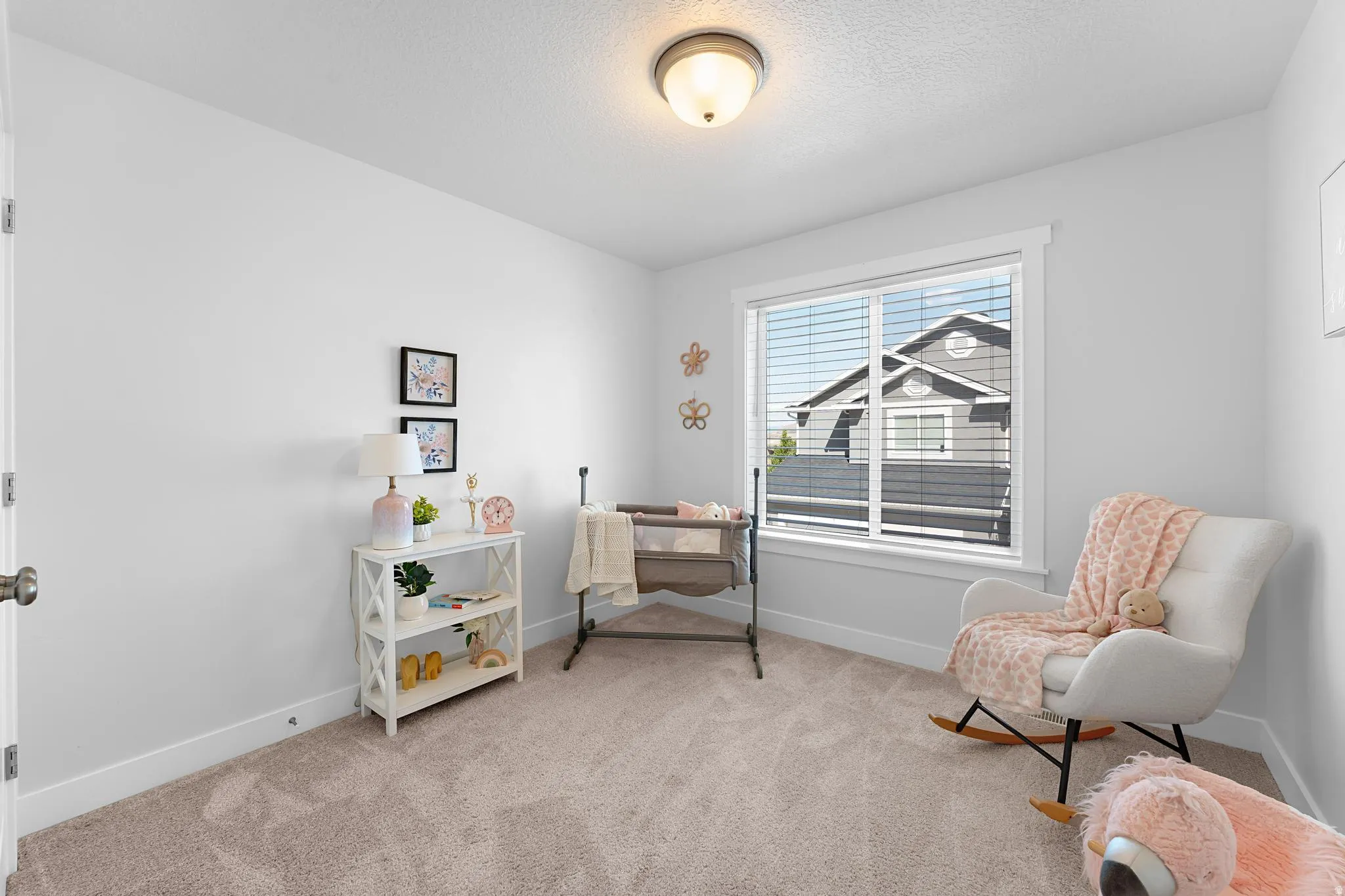 Sitting room featuring light colored carpet and a textured ceiling