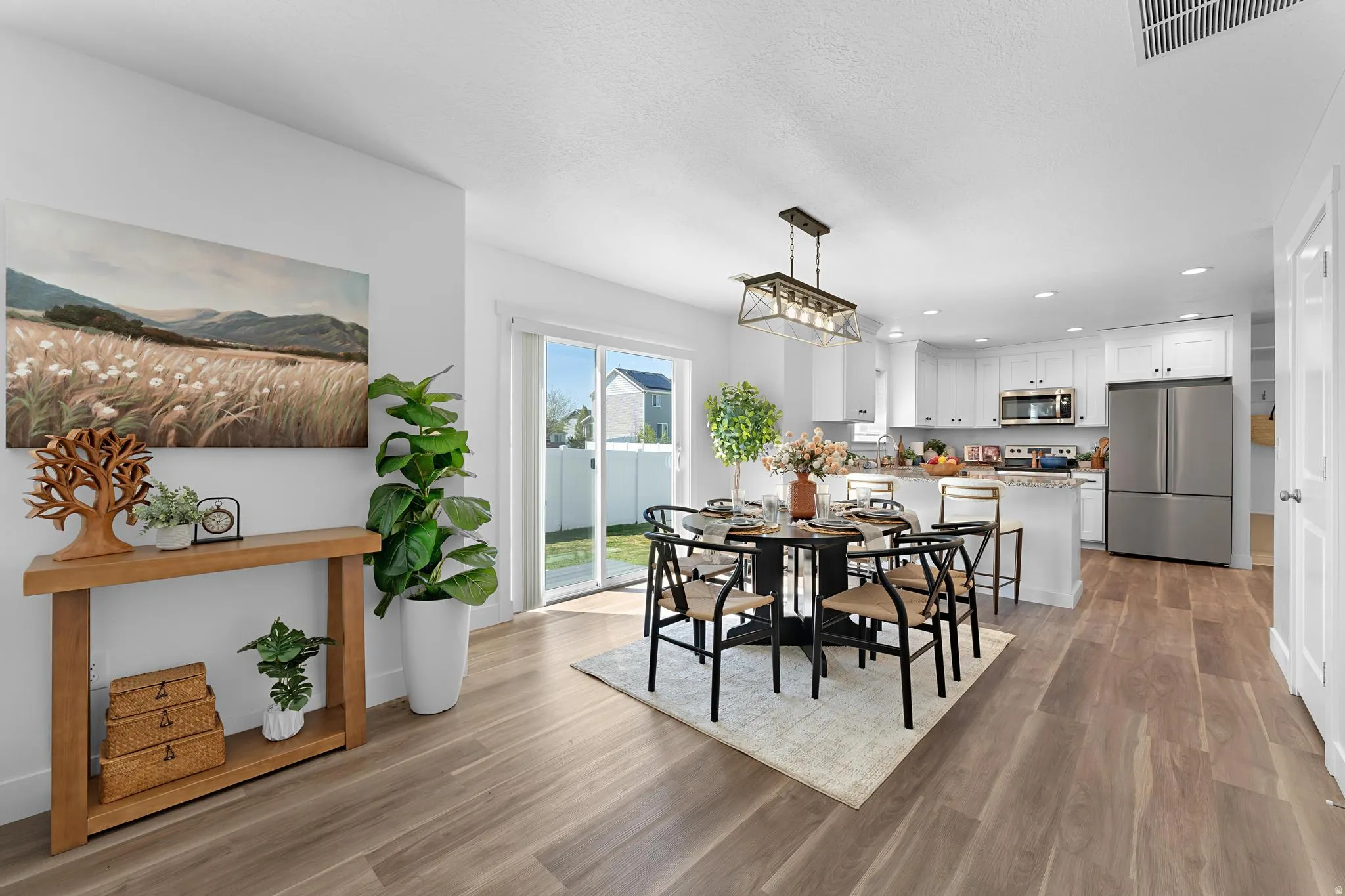 Dining room with light wood finished floors and recessed lighting