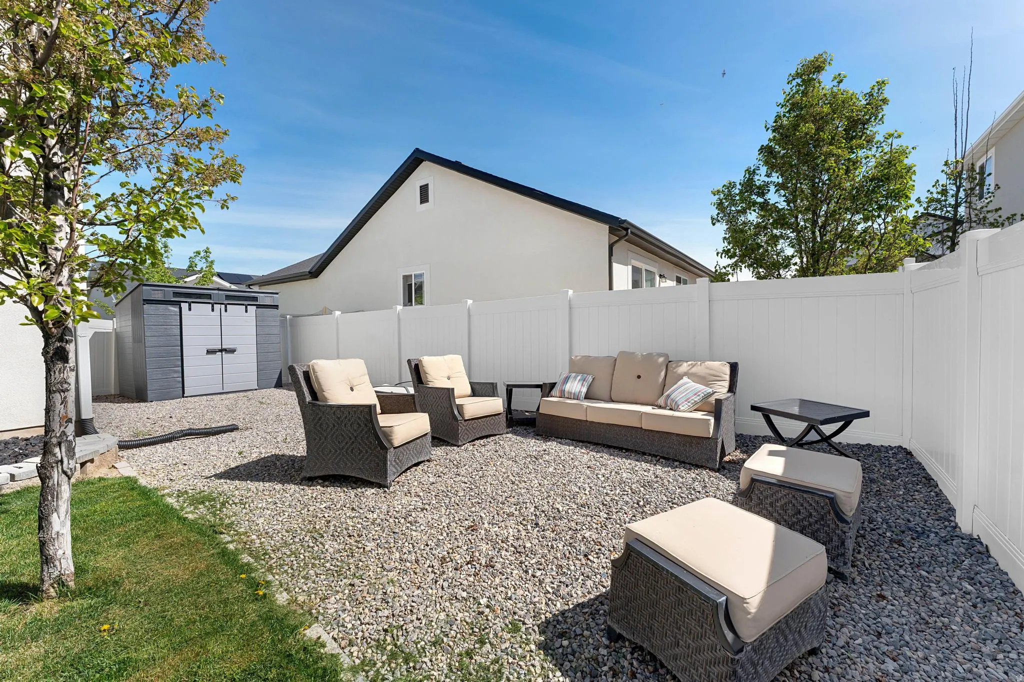 Fenced backyard with a storage shed, outdoor furniture, and a patio area