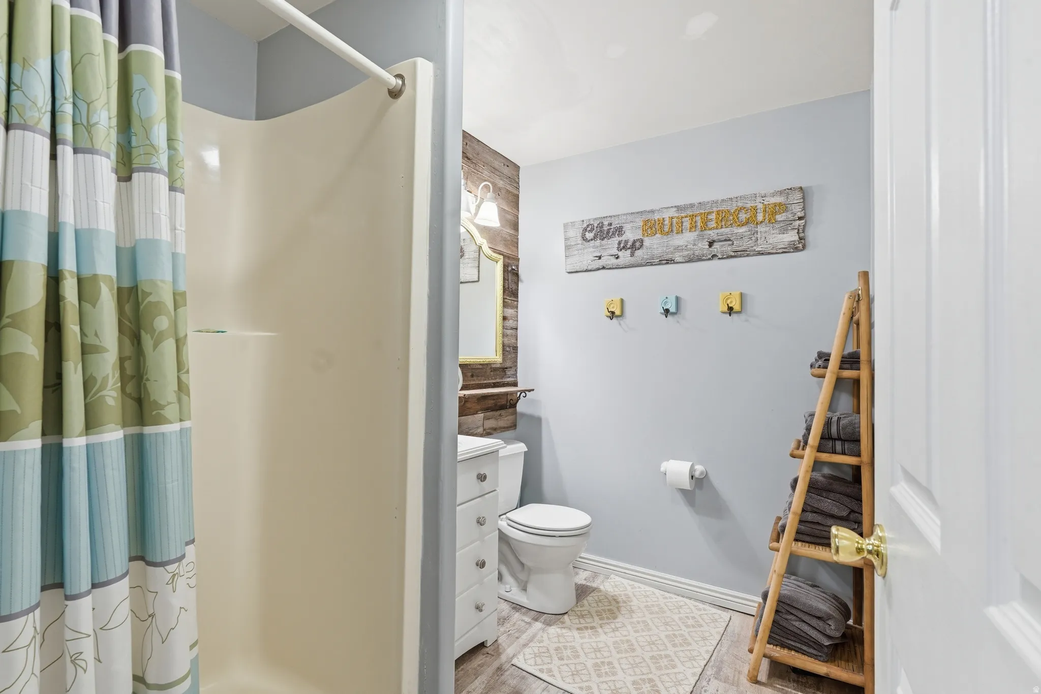 Full bath featuring a shower stall, vanity, and light wood-style flooring