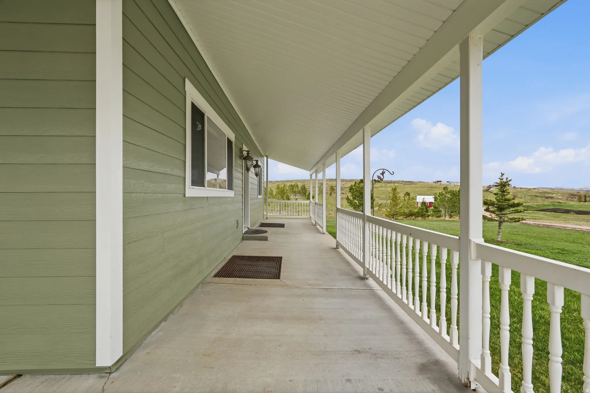 Covered porch featuring a rural view