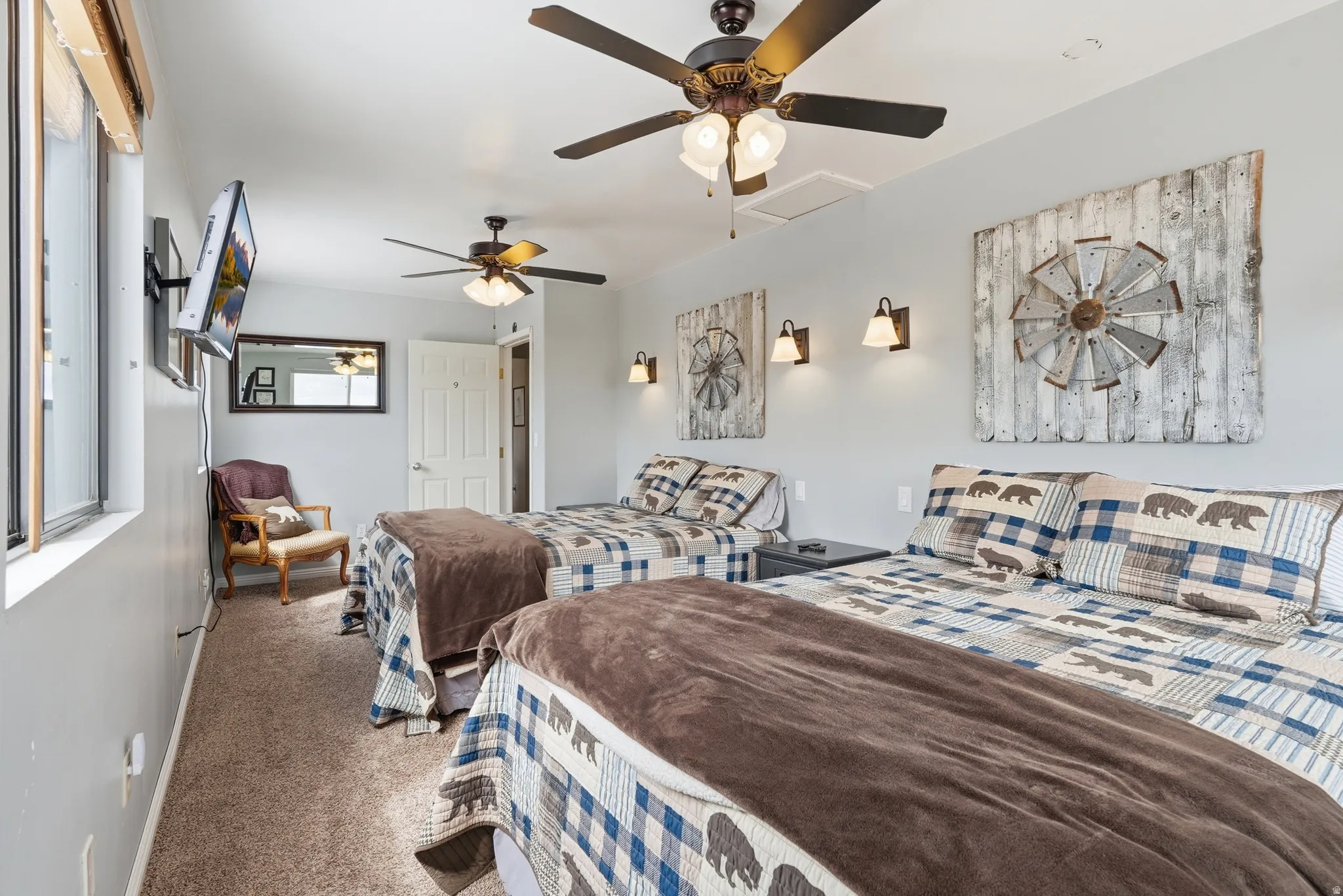 Carpeted bedroom with a ceiling fan and baseboards