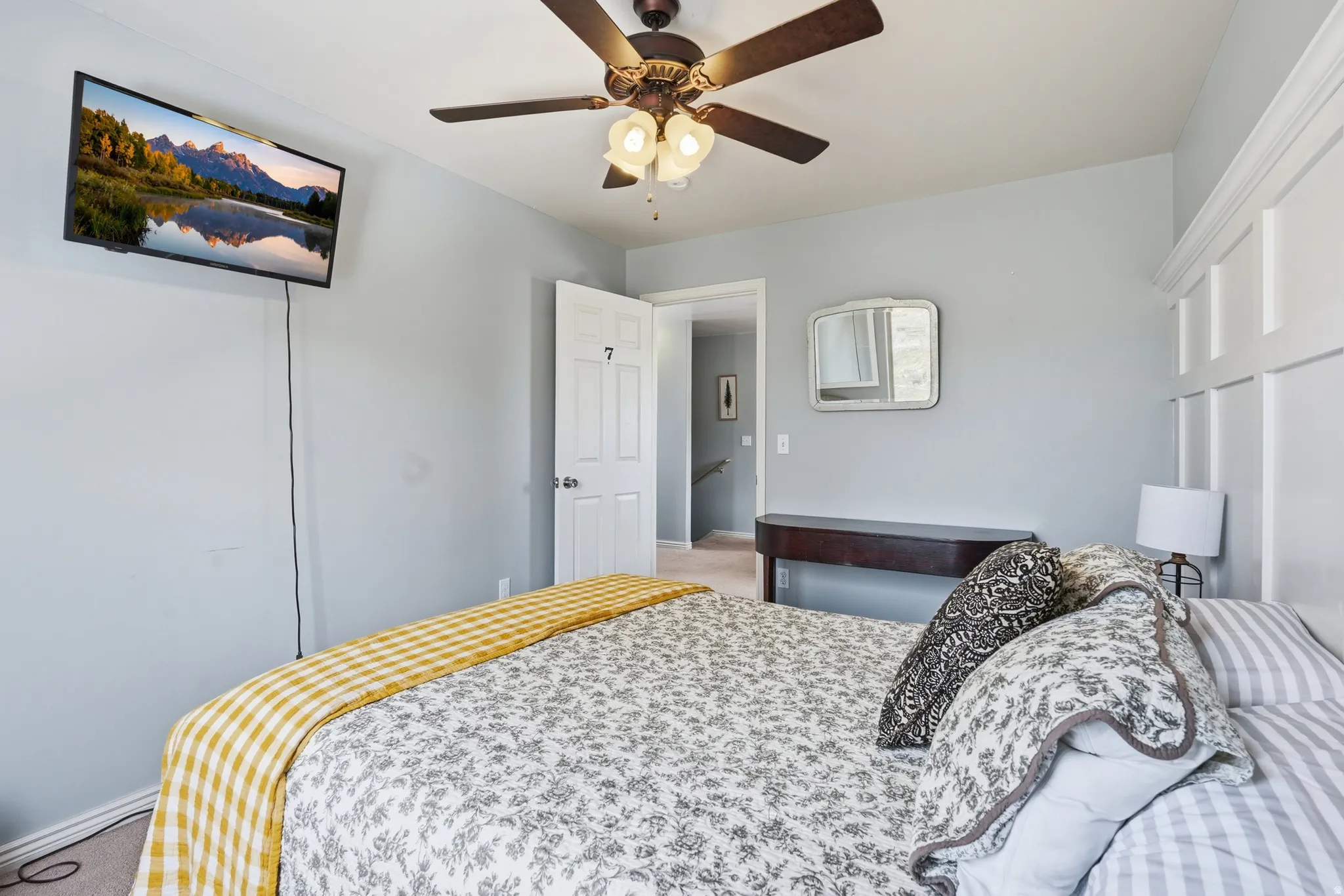 Bedroom with a ceiling fan and light colored carpet