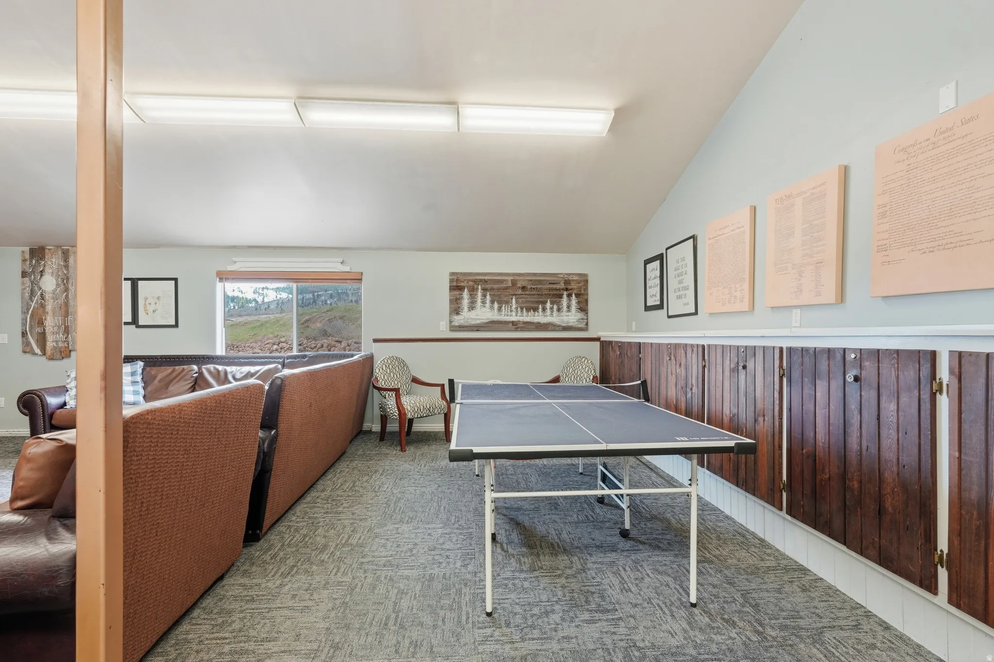 Game room featuring lofted ceiling, carpet floors, and wainscoting