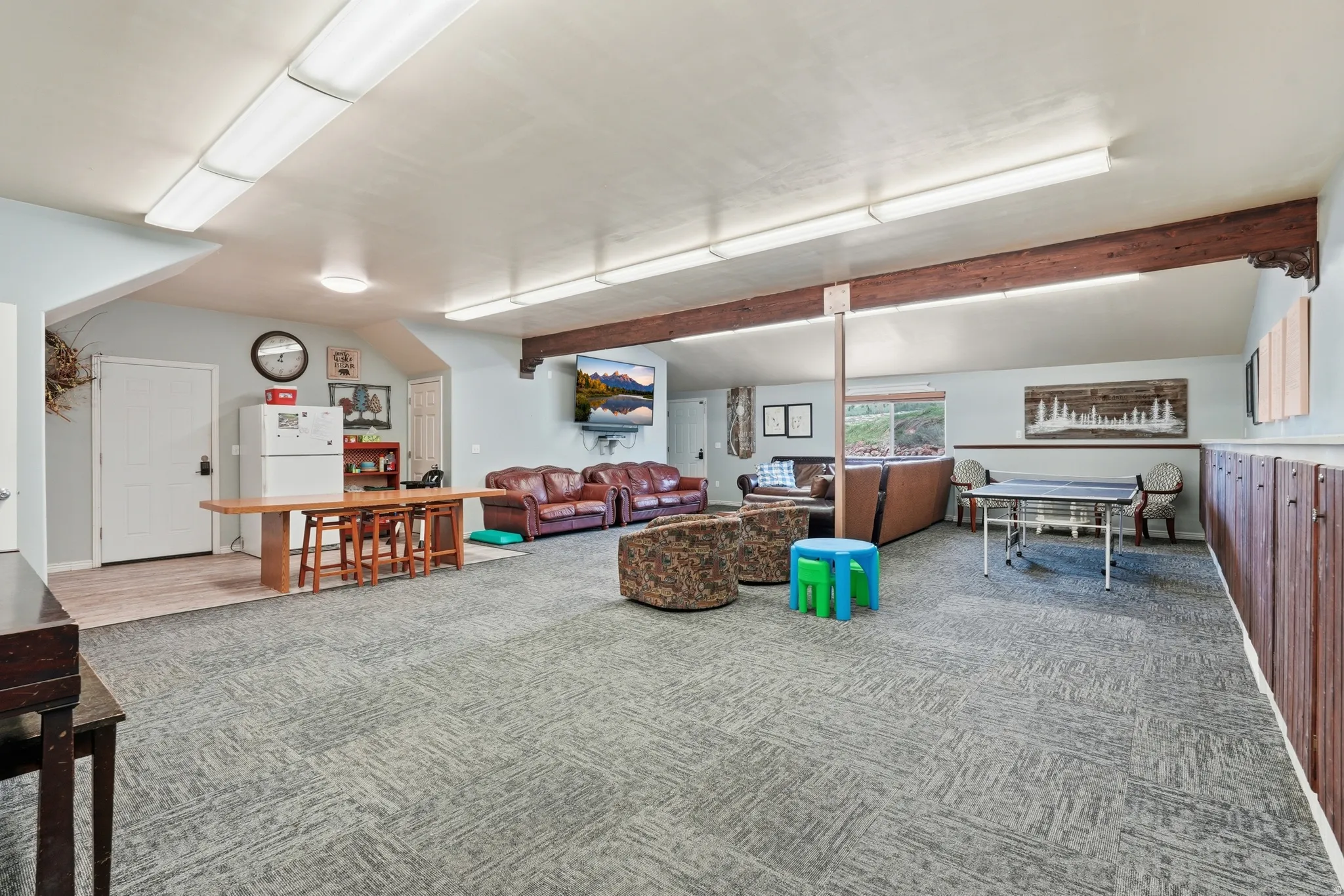 Living area featuring light carpet and vaulted ceiling with beams