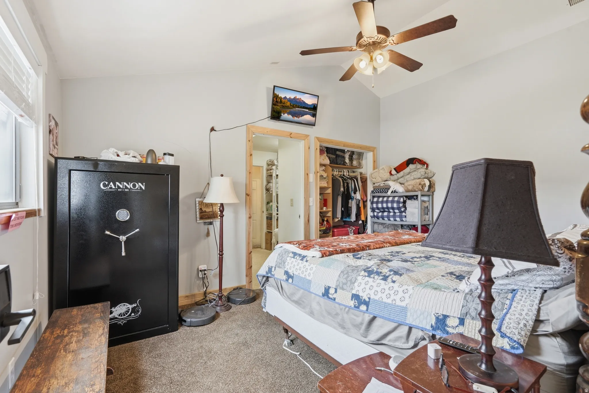Bedroom featuring carpet flooring, vaulted ceiling, a ceiling fan, and a walk in closet