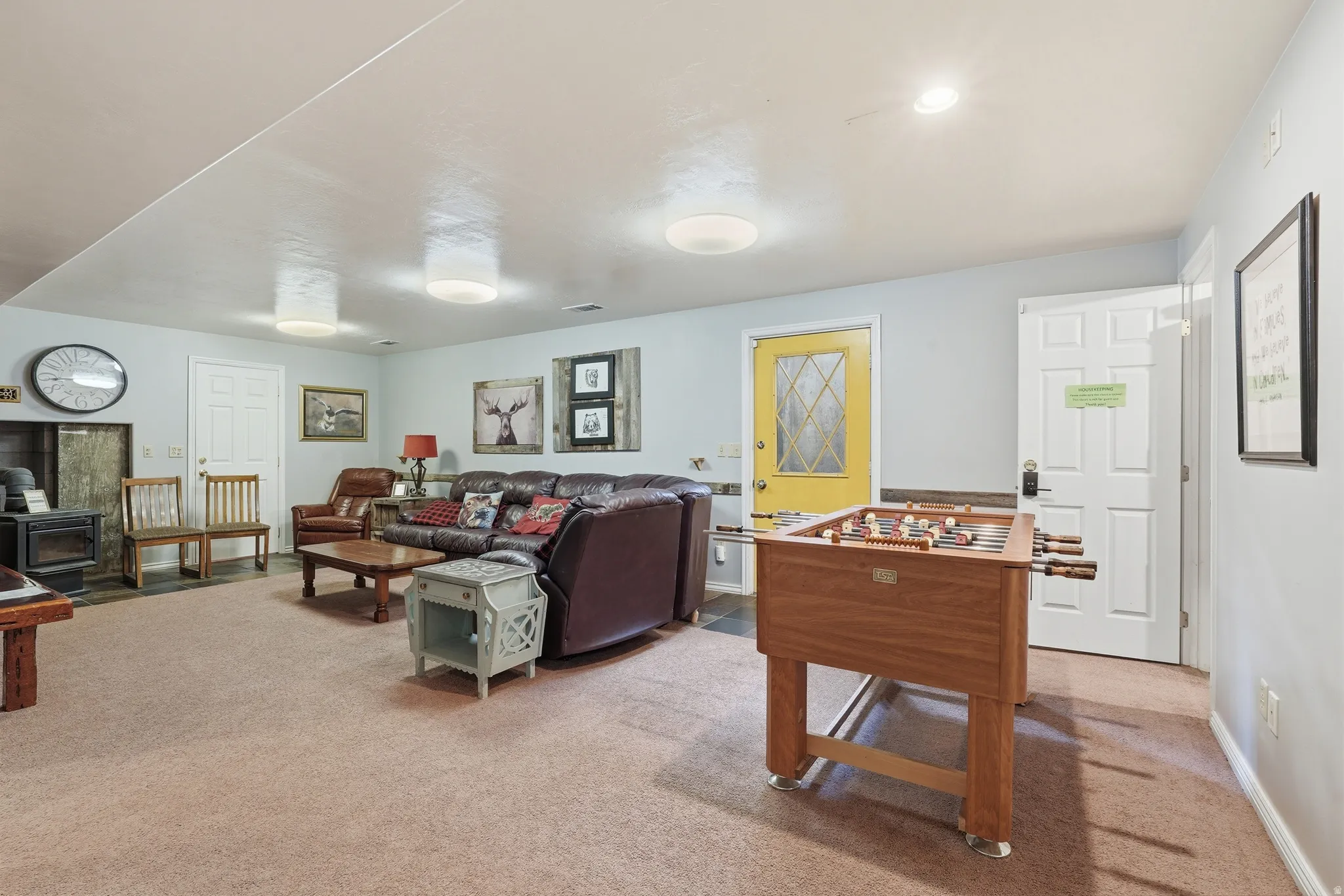 Living area featuring a wood stove and light colored carpet